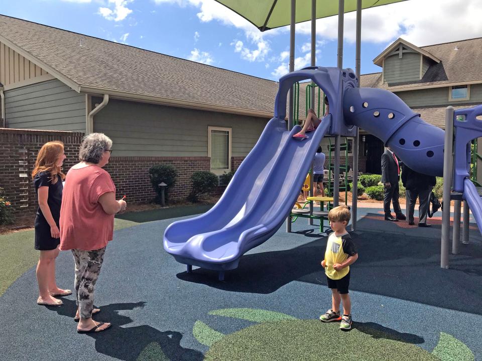 Family member and friends enjoy the newly renovated playground at the Ronald McDonald House in Pensacola.