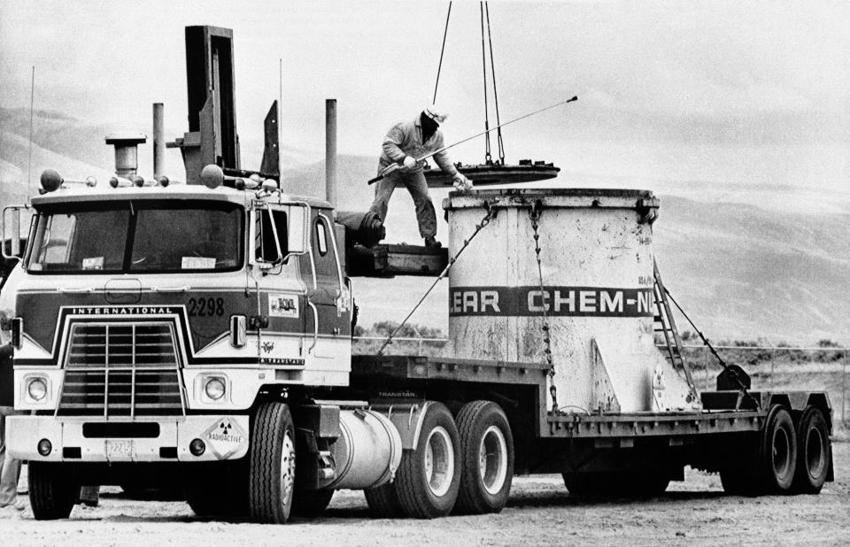 FILE - In this April 23, 1979 file photo workmen at Nuclear Engineer Co.'s Hanford, Washington site remove lid from canister holding sealed container of low level radio-action waste. The waste was transported to the Hanford waste disposal site from the Three Mile Island Nuclear Power Plant, Unit #1 in Harrisburg, Pa. A fight is raging in courts and Congress over where radioactive materials should be stored and how to safely get the dangerous remnants of decades of bomb-making and power generation to a permanent resting place. (AP Photo/Mason,File)