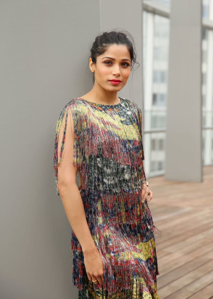 Freida Pinto poses during the Veuve Clicquot New Generation Award in a multi-colored fringe dress