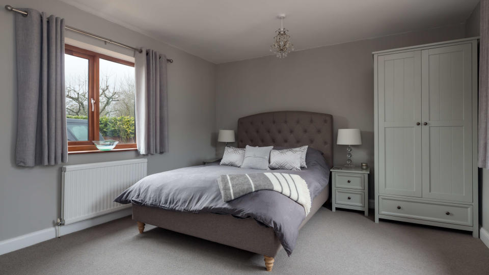 Double bedroom showing a radiator beneath a window with curtains hanging above