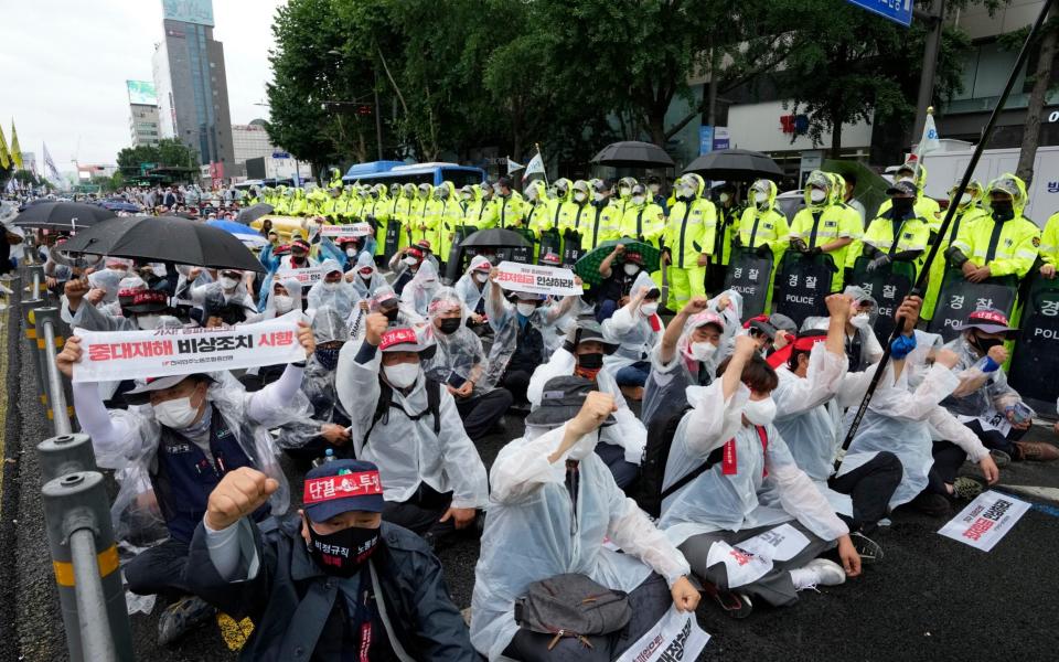 Workers shout slogans during a rally demanding job security in Seoul, South Korea, Saturday, July 3, 2021. Thousands of workers gathered ignoring the government's call to cancel the assembly feared to affect the fight against COVID-19. The banners read: "Revision of the labor law." (AP Photo/Ahn Young-joon) - AP