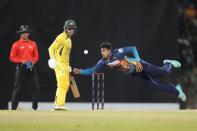 Sri Lanka's Maheesh Theekshana dives to catch a ball as Australia's Alex Carey watches during the fifth one-day international cricket match between Australia and Sri Lanka in Colombo, Sri Lanka, Friday, June 24, 2022. (AP Photo/Eranga Jayawardena)