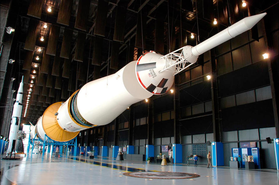 a large white rocket on display, in horizontal configuration, in a museum