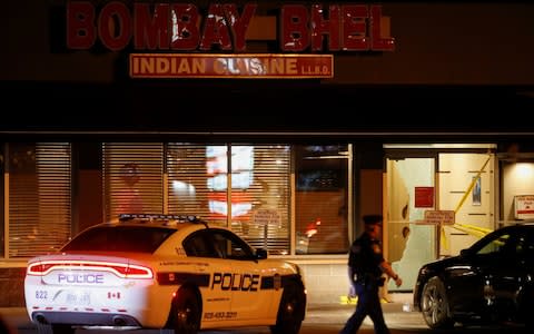 A police officer outside the Bombay Bhel restaurant - Credit: MARK BLINCH /Reuters