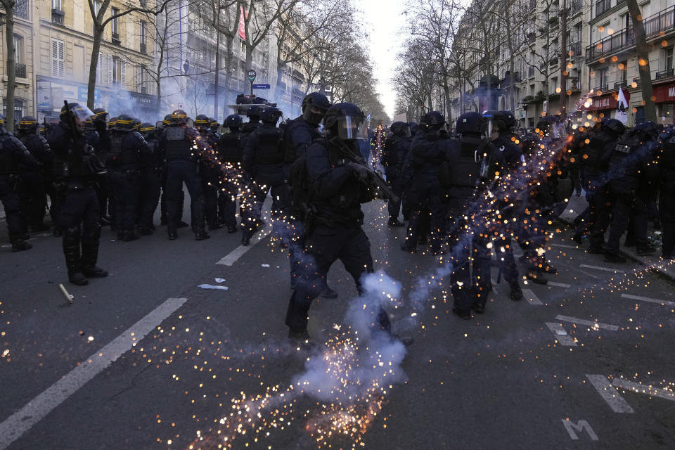 Policías antimotines en sus puestos mientras les lanzan proyectiles en una manifestación contra los planes de reformar el sistema de pensiones de Francia, en París, el sábado 11 de febrero de 2023. (AP Foto/Michel Euler)