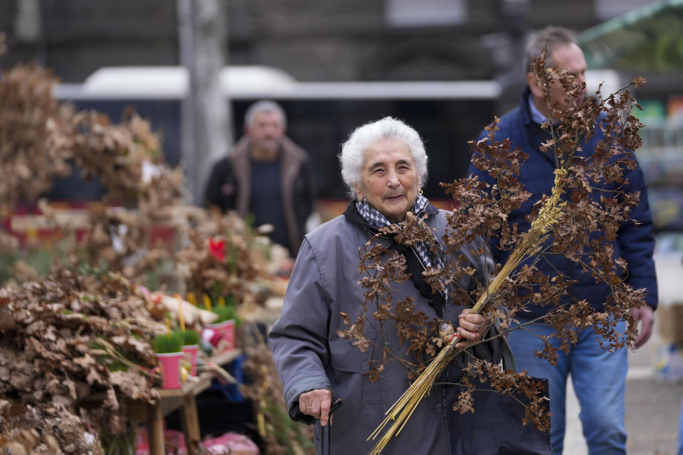 A woman holds dried oak branches, the Yule log symbol for the Orthodox Christmas Eve, in Belgrade, Serbia, Saturday, Jan. 6, 2024. Orthodox believers in Serbia celebrate Christmas on Jan. 7, according to the Julian calendar. (AP Photo/Darko Vojinovic)