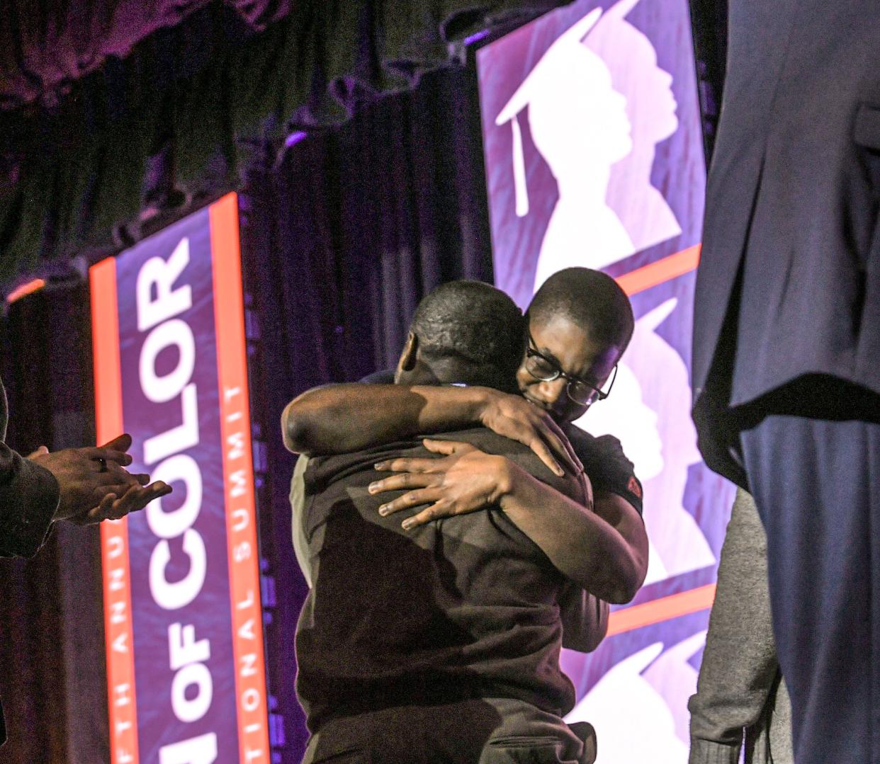 Slevensky Jules, right, of Carolina High School Tiger Alliance, reacts by hugging his father Montainor Jules after he was surprised with a $50,000 scholarship from Boeing  during the Clemson University Men of Color National Summit at the Greenville Convention Center in Greenville, S.C. Thursday, April 20, 2022.  