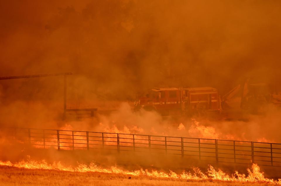 <p>Firefighters work as flames from the County Fire move through a property in Guinda, Calif. on July 1, 2018. (Photo: Josh Edelson/AFP/Getty Images) </p>