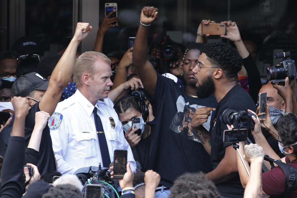 Richmond Police Chief William Smith, left, is confronted by a protester as he attempts to address a large crowd in front of City Hall, Tuesday June 2, 2020, in Richmond, Va. Richmond Mayor Levar Stoney apologized after police, the night before, lobbed tear gas at a group of peaceful demonstrators during a protest over the death of George Floyd, who died after being restrained by Minneapolis police officers on May 25. (AP Photo/Steve Helber)