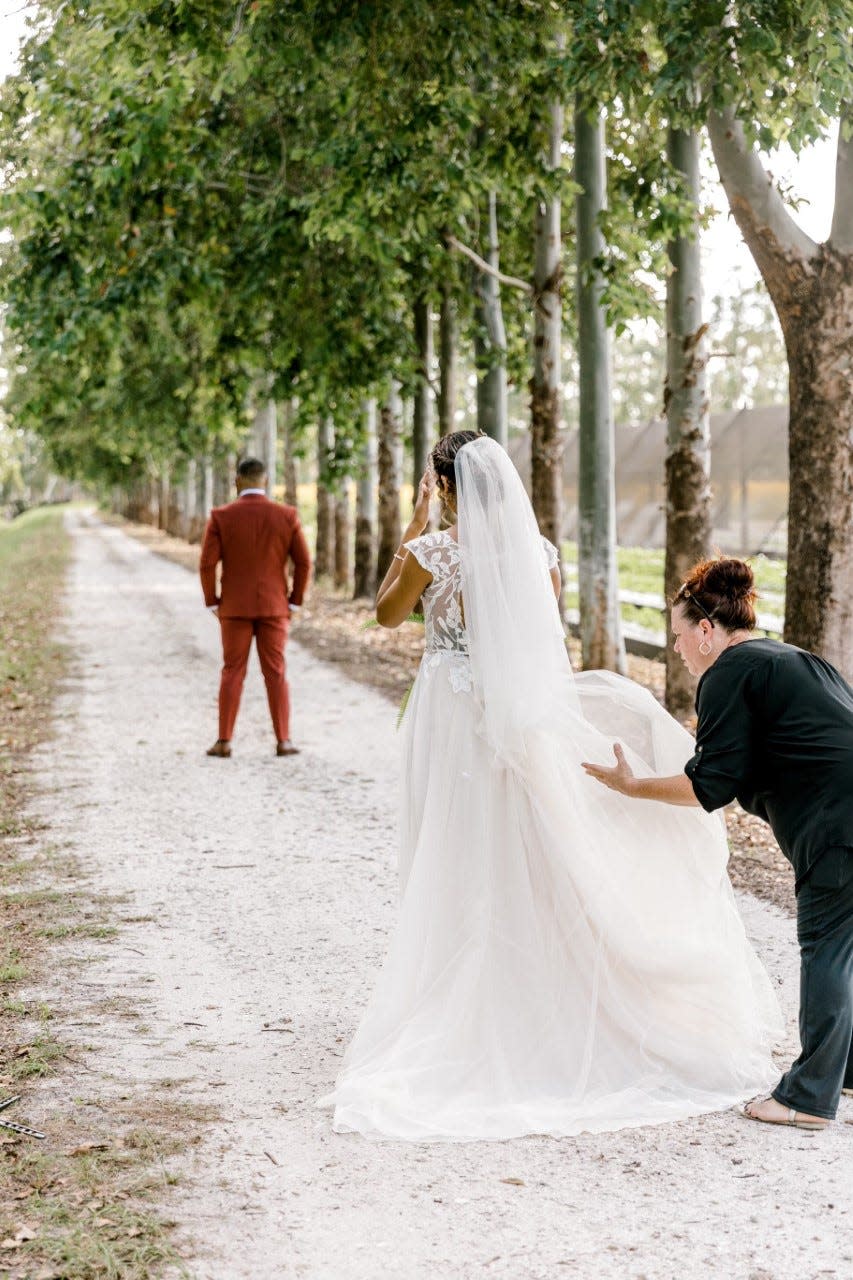 Wedding planner Natalie Harmon adjusts the train of a bride at Kai Kai Farm in Indiantown in October 2021.