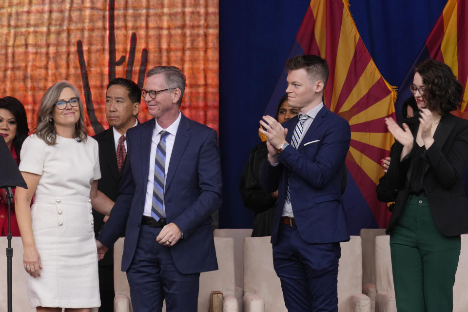 Arizona Democratic Gov. Katie Hobbs, left, pauses on stage as she stands next to husband Patrick Goodman, second from left, son Sam and daughter Hannah, right, after giving her inaugural address at the state Capitol in Phoenix, Thursday, Jan. 5, 2023. (AP Photo/Ross D. Franklin)