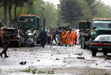 Afghan police and municipal workers clear debris from the site of a suicide bomb attack in Kabul, Afghanistan May 3, 2017. REUTERS/Omar Sobhani