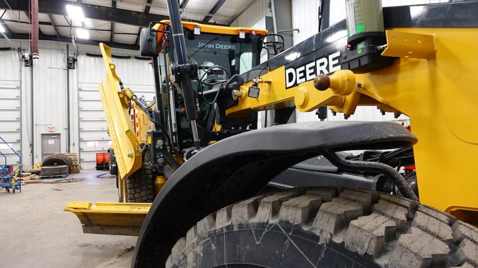 A brand new road grader sits in a public works garage in North Dundas