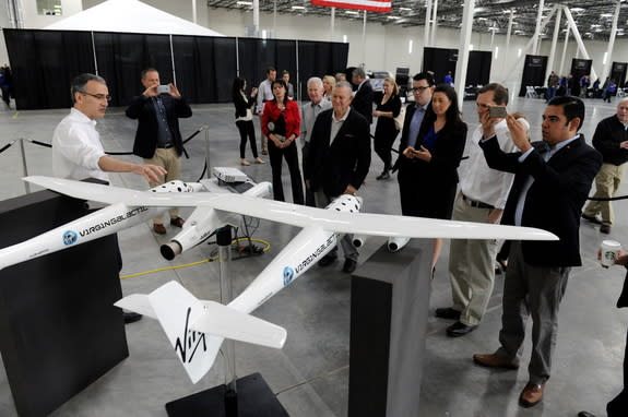 Steve Isakowitz (left), president of Virgin Galactic, explains the LauncherOne system to Rep. Dana Rohrabacher, Congressional representative for California, standing at center.