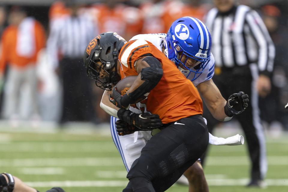 BYU linebacker Ace Kaufusi (18) tackles Oklahoma State running back Jaden Nixon (3) in the first half of an NCAA college football game Saturday, Nov. 25, 2023, in Stillwater, Okla. | Mitch Alcala, Associated Press