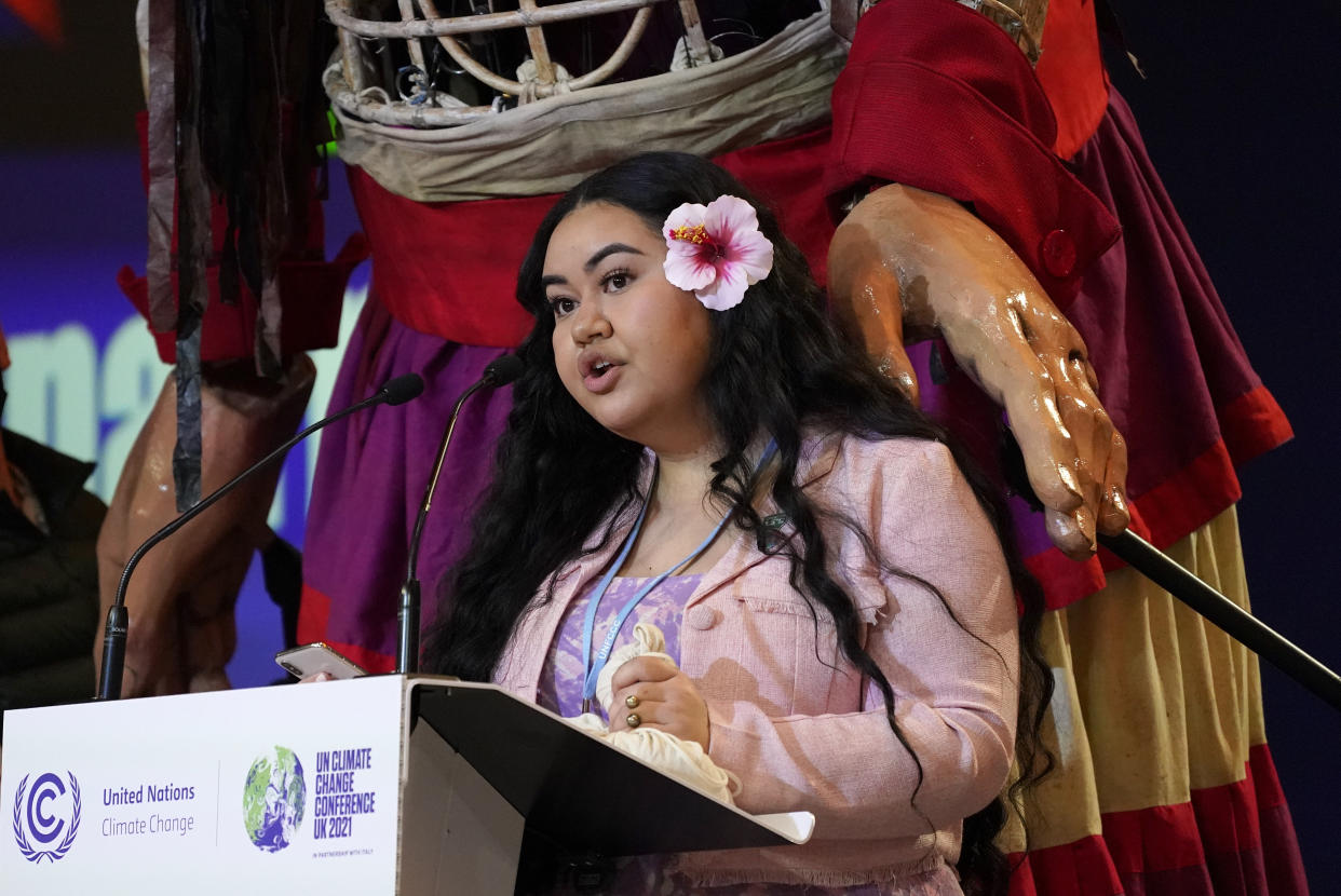 Brianna Fruean, an activist and environmental advocate for Samoa, speaks as the giant puppet Little Amal stands behind her inside the venue of the COP26 U.N. Climate Summit in Glasgow, Scotland, Tuesday, Nov. 9, 2021. The U.N. climate summit in Glasgow has entered it's second week as leaders from around the world, are gathering in Scotland's biggest city, to lay out their vision for addressing the common challenge of global warming. (AP Photo/Alberto Pezzali)