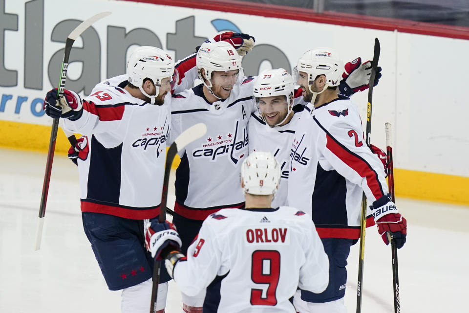 Washington Capitals' Conor Sheary (73) celebrates with Justin Schultz (2), Nicklas Backstrom (19), Dmitry Orlov (9) and Tom Wilson (43) after scoring a goal during the second period of the tema's NHL hockey game against the New Jersey Devils on Sunday, April 4, 2021, in Newark, N.J. (AP Photo/Frank Franklin II)