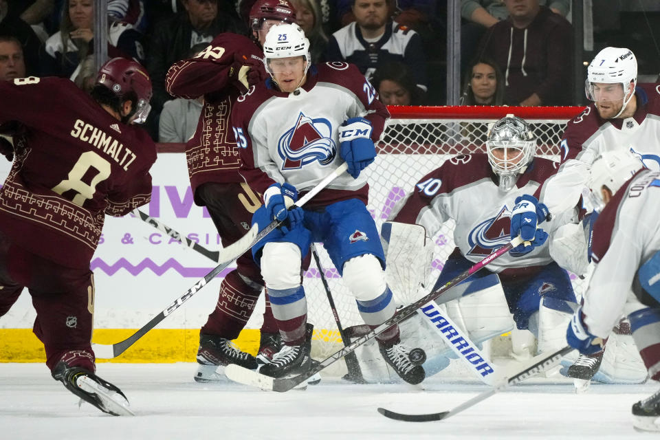 Arizona Coyotes center Nick Schmaltz (8) fires his goal-scoring shot at Colorado Avalanche goaltender Alexandar Georgiev (40) as the puck goes past Avalanche right wing Logan O'Connor (25) and defenseman Devon Toews (7) and Coyotes center Logan Cooley, second from left, during the second period of an NHL hockey game Thursday, Nov. 30, 2023, in Tempe, Ariz. (AP Photo/Ross D. Franklin)