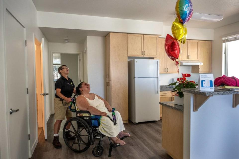 As Holly Porter, a quadriplegic who was living in a hospital bed at Camp Resolution, is wheeled around her new apartment by Hope Cooperative’sTracey Knickerbocker they react in joy on Thursday, June 29, 2023. Knickerbocker had bought Holly a plant, balloons and assorted deli meats in celebration of her getting her keys and getting housed.“Relieved that it finally happened, there ain’t nothing else right now. Im very excited I just don’t think it’s sunk in yet,” said Porter. Renée C. Byer/rbyer@sacbee.com