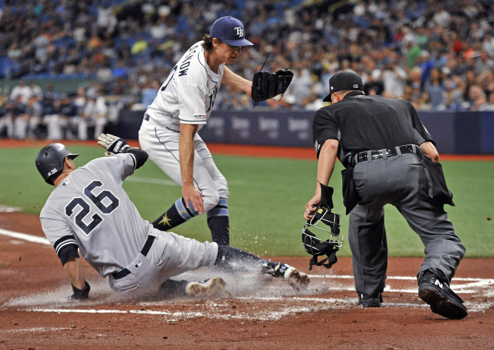 Home plate umpire Cory Blaser, right, watches as New York Yankees' DJ LeMahieu (26) scores on a passed ball, as pitcher Tyler Glasnow, center, covers the plate during the first inning of a baseball game Friday, May 10, 2019, in St. Petersburg, Fla. (AP Photo/Steve Nesius)