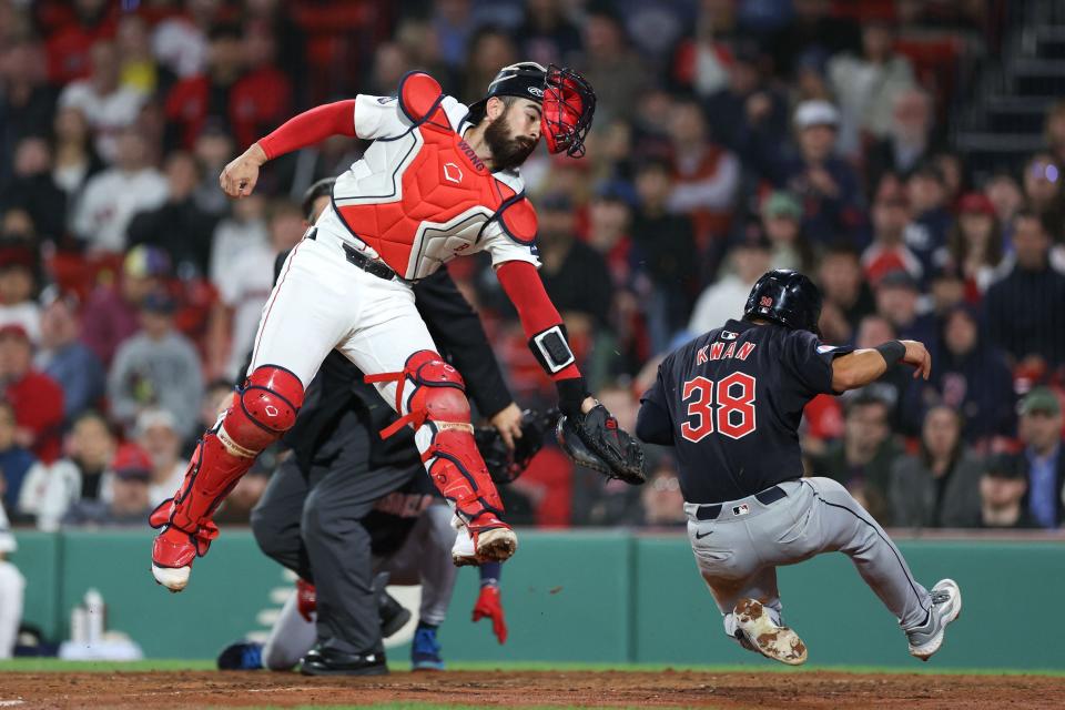 Guardians left fielder Steven Kwan slides past a tag attempt by Red Sox catcher Connor Wong (12) during the 11th inning at Fenway Park, April 16, 2024, in Boston.