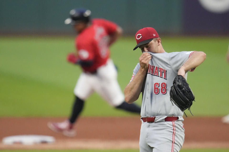 Cincinnati Reds pitcher Carson Spiers (68) wipes his face as Cleveland Guardians' Josh Naylor, left, runs around second base on a home run ball hit by Lane Thomas in the first inning of a baseball game in Cleveland, Tuesday, Sept. 24, 2024. (AP Photo/Sue Ogrocki)