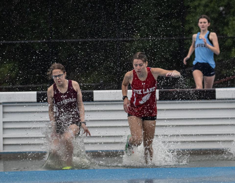 Scarsdale's Rachel Rakower (l), who went on to win, lands in the water jump next to Fox Lane's Willie Cuono, the third-place finisher, during the  Section 1 Class A steeplechase championships at Hendrick Hudson High School May 24, 2023.