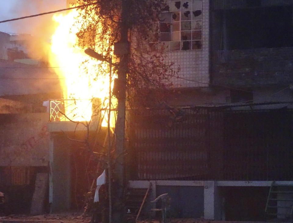 A house goes up in flames following violence between two groups in New Delhi, India, Tuesday, Feb. 25, 2020. At least 10 people were killed in two days of clashes that cast a shadow over U.S. President Donald Trump's visit to the country. (AP Photo/Dinesh Joshi)