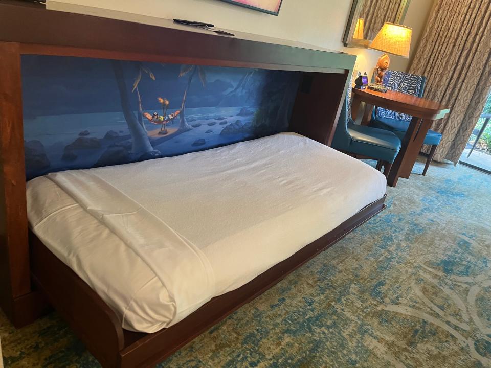 disney artwork on the back of a pull-down bed in a hotel room