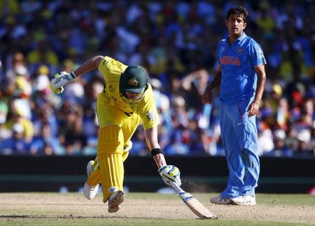 India's bowler Mohit Sharma (R) watches as Australian batsman Steve Smith safely makes his ground during their Cricket World Cup semi-final match in Sydney, March 26, 2015. REUTERS/David Gray