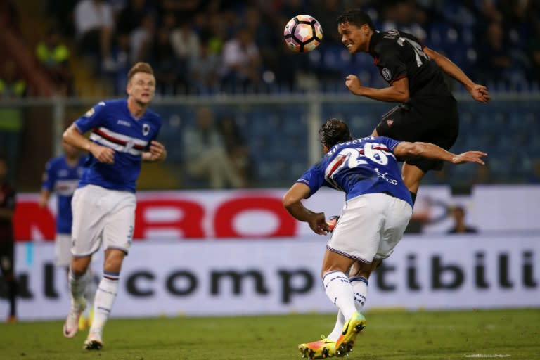 AC Milan's Colombian forward Carlos Bacca (R) heads the ball during the Italian Serie A football match