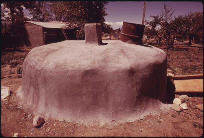 This photo from June 1974 shows a well housing that architect and experimental house builder Michael Reynolds built from old tires that have been covered with plaster.