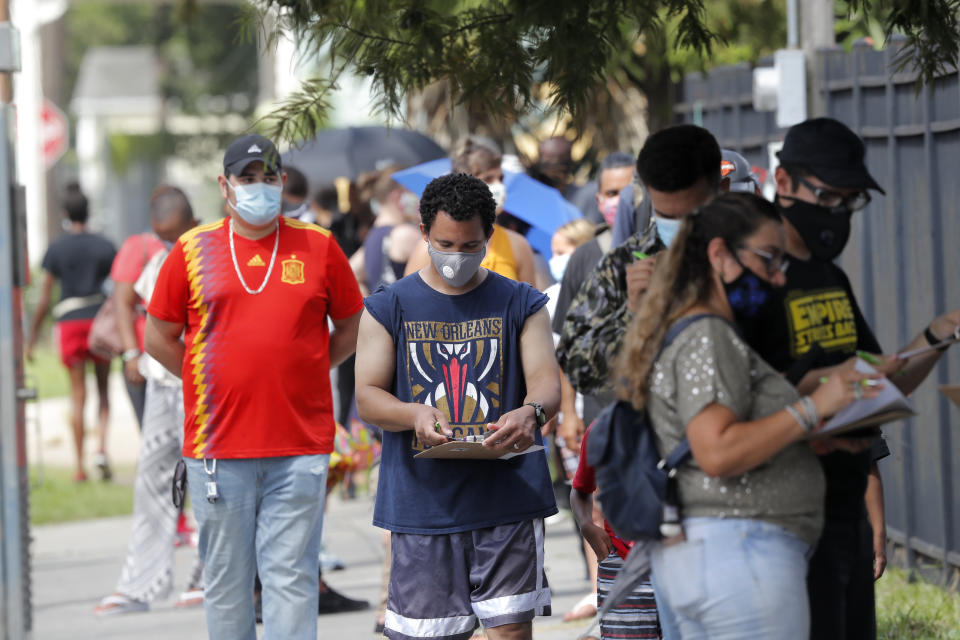 People line up for COVID-19 testing at a mobile testing site in New Orleans, Wednesday, July 8, 2020. Testing sites in New Orleans have been running out of their daily allocation of tests within minutes of opening. (AP Photo/Gerald Herbert)