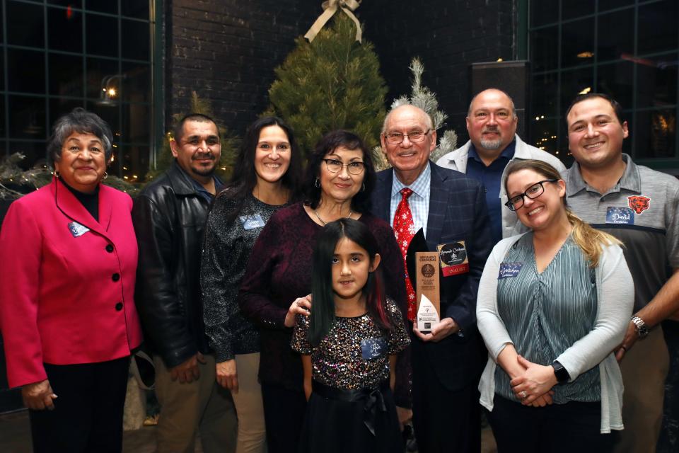 Excalibur winner Armando Cardenas poses with his family Thursday, Dec. 14, 2023, during the Excalibur and Excelsior awards ceremony at Prairie Street Brewing Co. in Rockford.