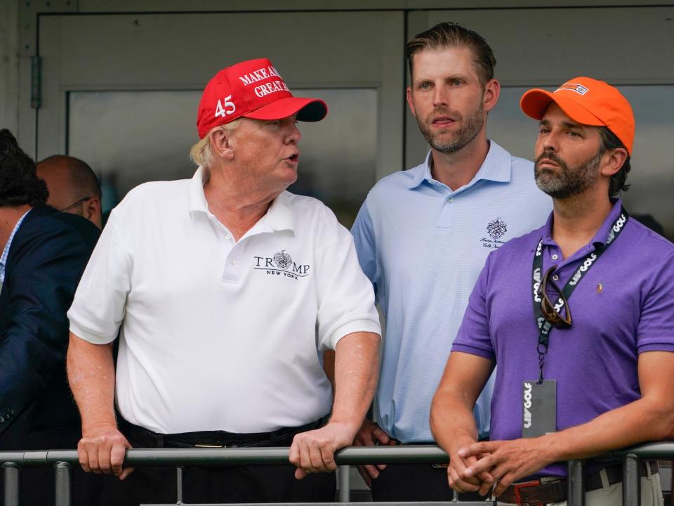 Former President Donald Trump, left, Eric Trump, center, and Donald Trump Jr. watch golfer during the final round of the Bedminster Invitational LIV Golf tournament in Bedminster, N.J., Sunday, July 31, 2022.