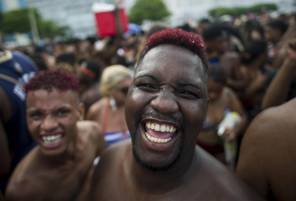 FILE - in this Jan. 12, 2020 file photo, revelers smile as they look on the camera during the "Bloco da Favorita" street party on Copacabana beach, Rio de Janeiro, Brazil. The city announced on Thursday, Sept. 24, said it has delayed its annual Carnival parade, saying the global spectacle cannot go ahead in February because of Brazil’s continued vulnerability to the new coronavirus pandemic, but has yet to announce a decision about the Carnival street parties that take place across the city. (AP Photo/Bruna Prado, File)