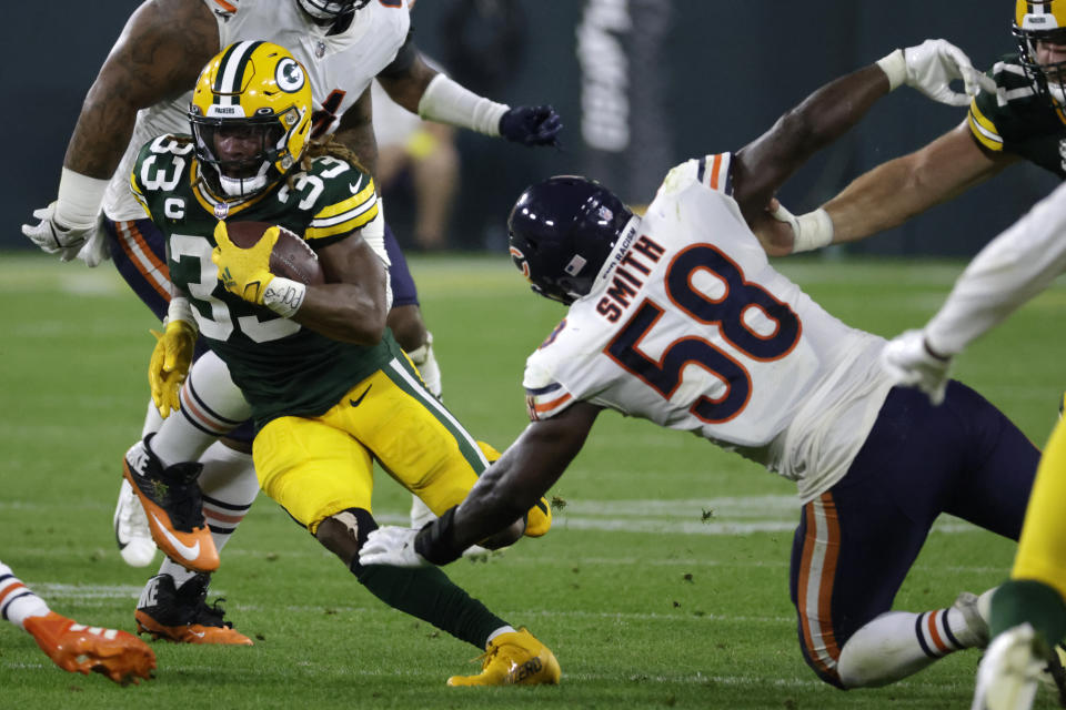 Green Bay Packers running back Aaron Jones (33) runs from Chicago Bears linebacker Roquan Smith (58) during the first half of an NFL football game Sunday, Sept. 18, 2022, in Green Bay, Wis. (AP Photo/Mike Roemer)