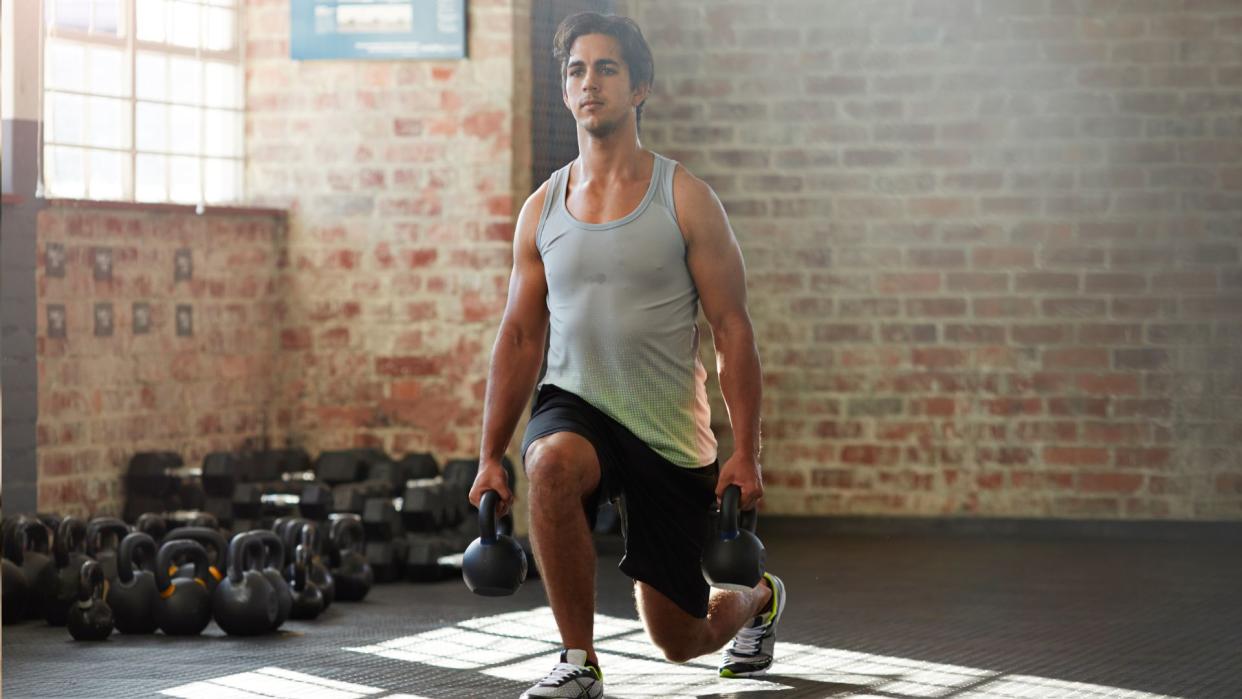  Man performing kettlebell lunges. 