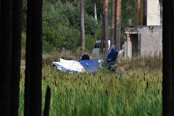 A law enforcement officer works at the site of a plane crash near the village of Kuzhenkino, Tver region, on 24 August 2023 (AFP via Getty Images)