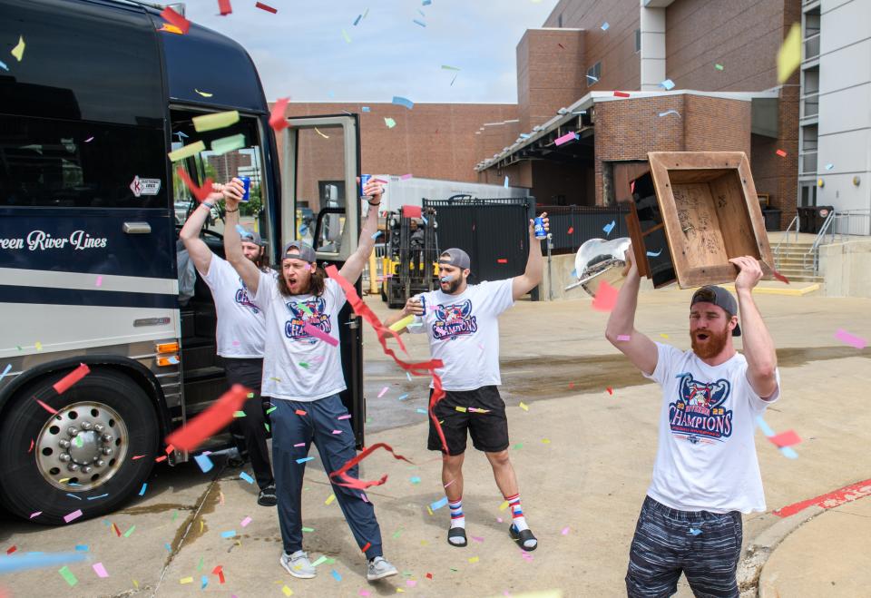 Confetti flies as Alec Hagaman, far right, of the Peoria Rivermen hoists the President's Cup and teammates Eric Levine, foreground, Mike Gurtler, to his right, and Cody Dion exit the bus to the cheers of their fans on their return to the Peoria Civic Center on Wednesday, May 4, 2022 from their SPHL championship run in Roanoke, Virginia. The Rivermen defeated the Roanoke Rail Yard Dawgs 3-1 in the best-of-5 series for the title.