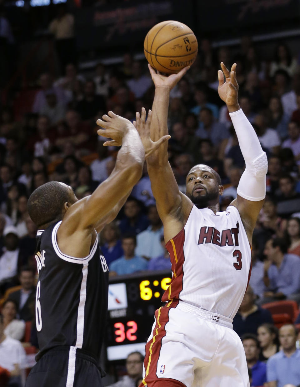 Miami Heat guard Dwyane Wade (3) takes a shot against Brooklyn Nets forward Alan Anderson (6) during the first half of an NBA basketball game, Wednesday, March 12, 2014, in Miami. (AP Photo/Wilfredo Lee)