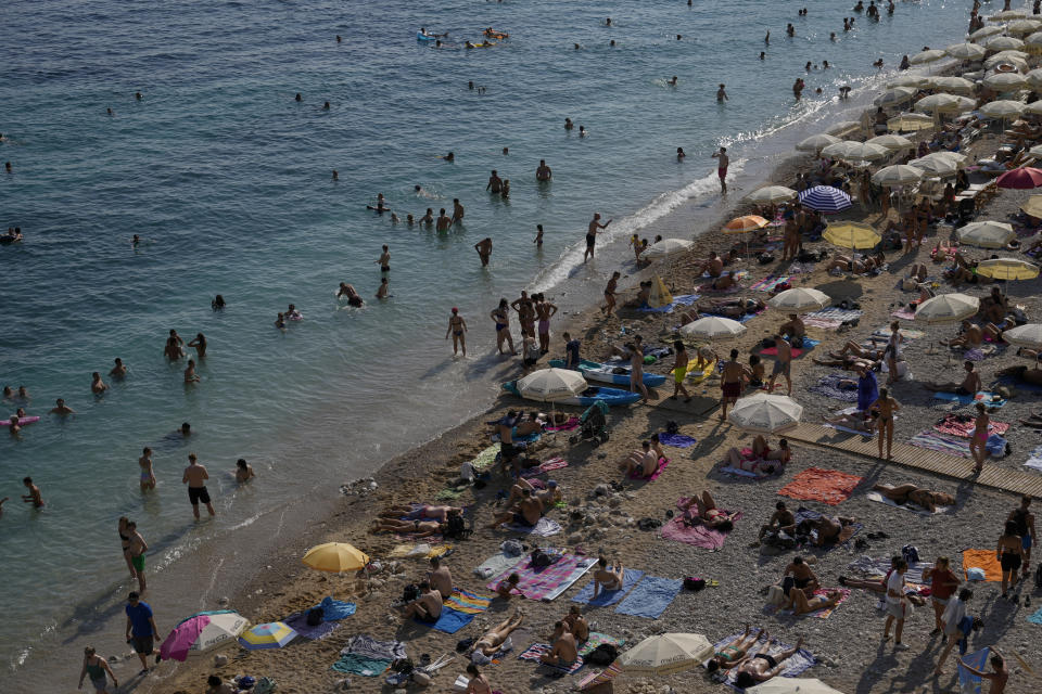 Holidaymakers enjoy the weather on a beach, in Dubrovnik, Croatia, Friday, Aug. 13, 2021. Summer tourism has exceeded even the most optimistic expectations in Croatia this year. Beaches along the country's Adriatic Sea coastline are swarming with people. Guided tours are fully booked, restaurants are packed and sailboats were chartered well in advance. (AP Photo/Darko Bandic)