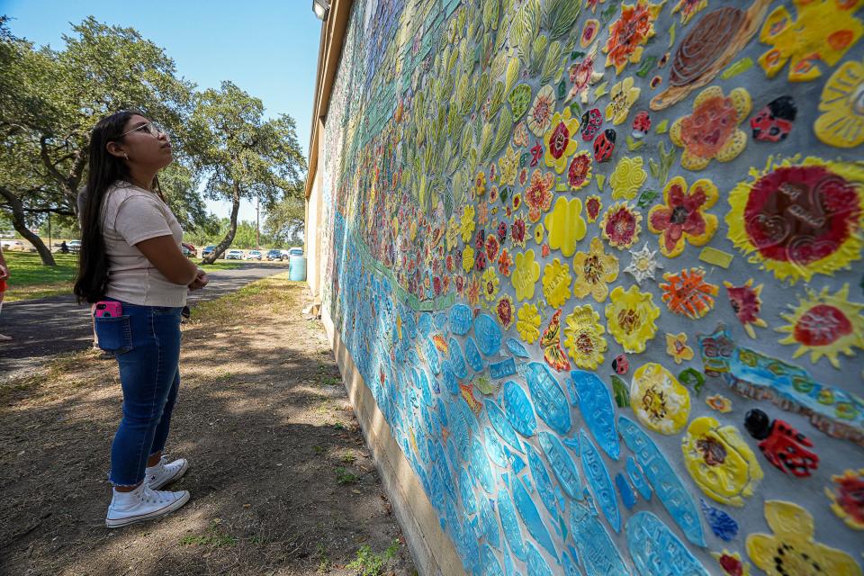 Uvalde elementary student Isabella Cobarrubia looks for her tile in the new mural. Art therapists visited Uvalde multiple times a month for several months for sessions with community members, teachers and students from various schools. Tiles created at the sessions were used in the final mural.
