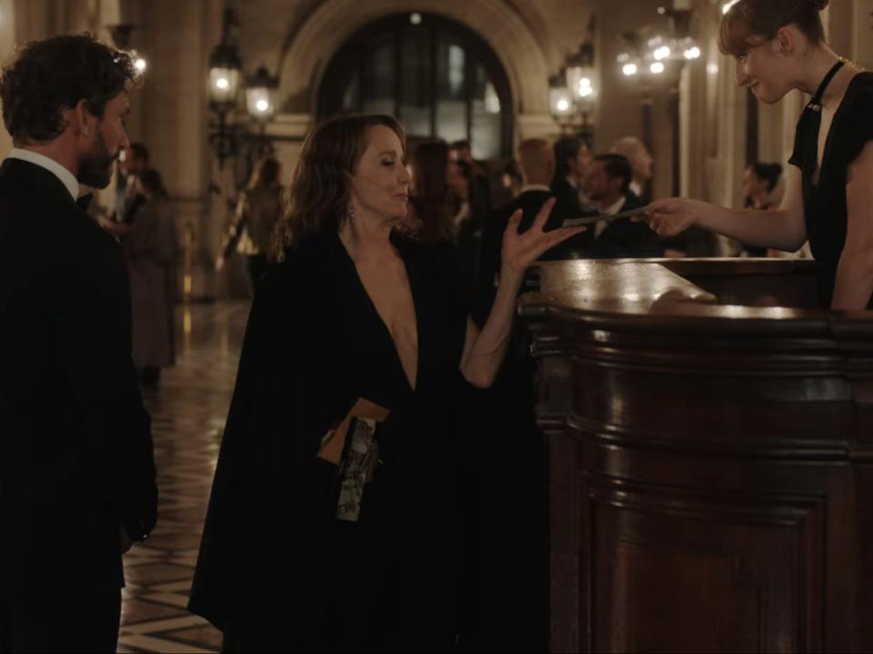 sylvie taking a ticket from an employee at the opera on emily in paris season three episode nine