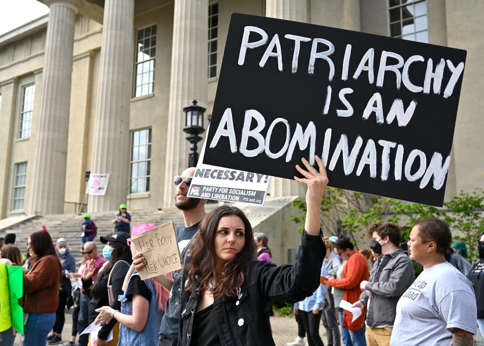 An abortion rights supporter looks down Jefferson Street toward a group of anti-abortion supporters during a pro-choice rally outside the Louisville Metro Hall, Wednesday, May. 4, 2022 in Louisville Ky.