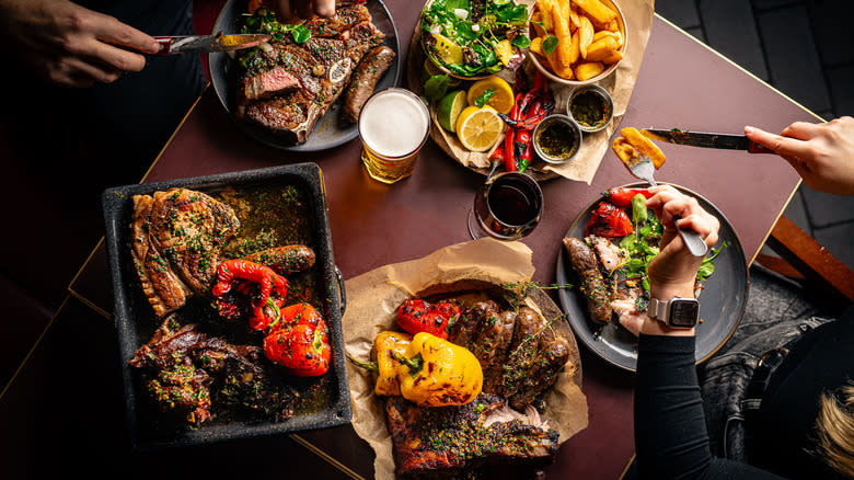 couple at table with grilled meats and veg