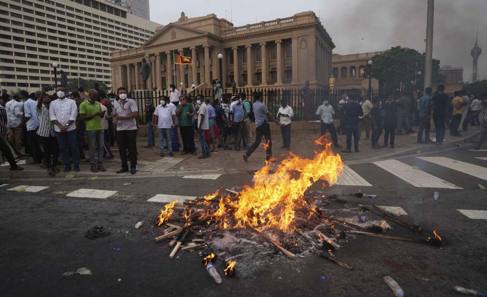 FILE - Supporters of Sri Lanka's main opposition burn placards during a protest outside President Gotabaya Rajapaksa's office in Colombo, Sri Lanka, March 15, 2022. With one brother president, another prime minister and three more family members cabinet ministers, it appeared that the Rajapaksa clan had consolidated its grip on power in Sri Lanka after decades in and out of government. With a national debt crisis spiraling out of control, it looks like the dynasty is nearing its end with Prime Minister Mahinda stepping down on Monday, May 9, 2022, and the three Rajapaksas resigning their cabinet posts in April, but the family is not going down without a fight. (AP Photo/Eranga Jayawardena, File)