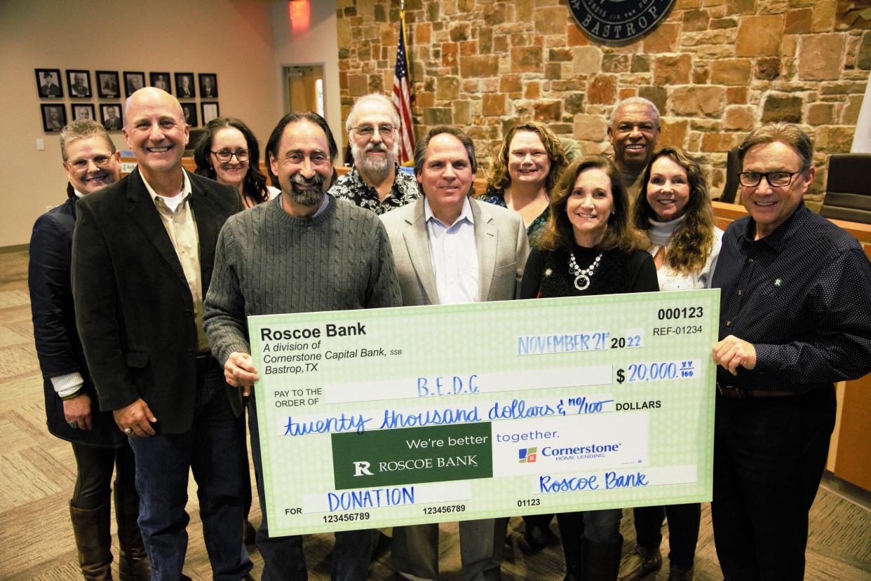 The board of directors of the Bastrop Economic Corporation receive a $20,000 grant – the first of five installments totaling $100,000 – donated by Roscoe State Bank for business development in Bastrop County. Pictured in the front row from left are Rick Womble, Roscoe State Bank executive vice president; board chair Ron Spencer; BEDC chief executive officer Bret Gardella; board member Mayor Connie Schroeder; board vice chair Jenn Wahl; and Roscoe business development officer Johnny Sanders. At back from left are BEDC business development officer Jean Riemenschneider; administrative assistant Ashley Allnutt; board secretary/treasurer Richard Smarzik; BEDC operations manager Angela Ryan; board member Charles Washington.