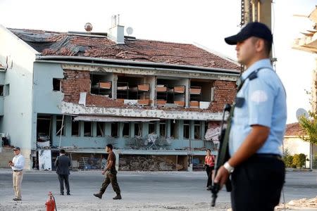 An armed policeman stands at the gate to the Turkish police special forces base damaged by fighting during a coup attempt in Ankara,Turkey, July 19, 2016. REUTERS/Baz Ratner