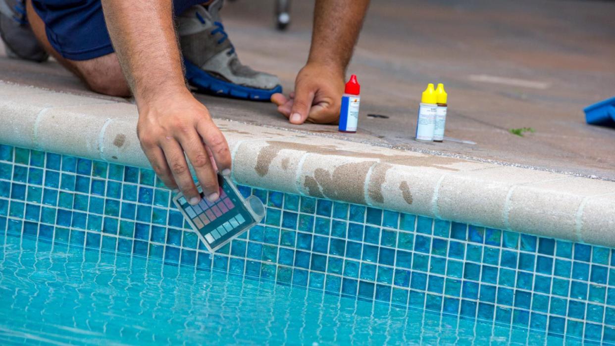 A man using a pool testing kit